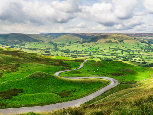 A bunch of fields surrounded on all sides by hills forming a shallow valley.