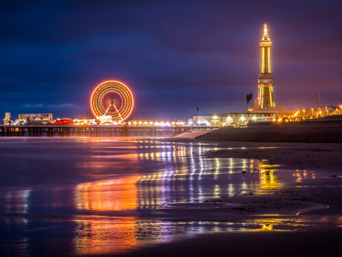 Blackpool beach with the Big Wheel and Blackpool Tower illuminated in the background