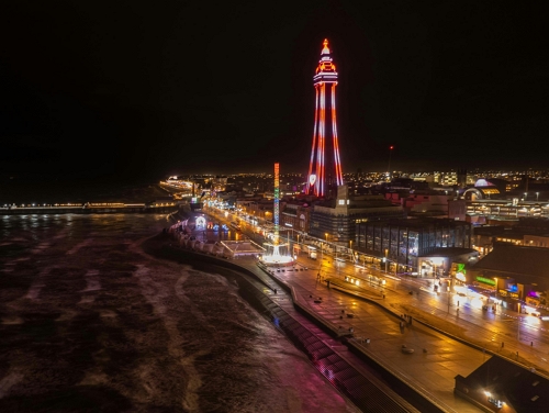 Aerial view of Blackpool Tower illuminated at night with the promenade in front