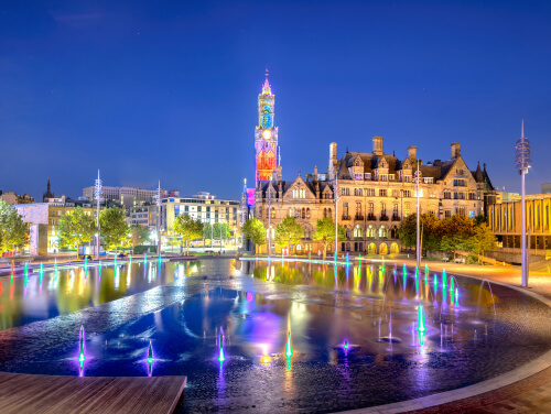 Bradford city centre at night with fountain illuminated by lights