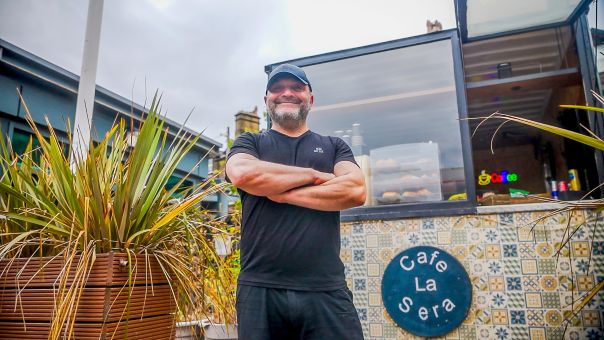 Owner smiling outsife cafe le sera