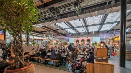 The Chester Market Hall filled to capacity with people sitting at tables and eating from food they got from surrounding stalls.