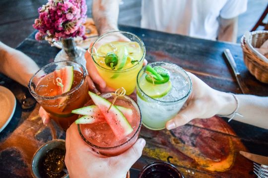 A group enjoying 4 different cocktails