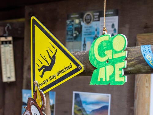 A sign for Go Ape as well as a yellow "always stay attached" sign