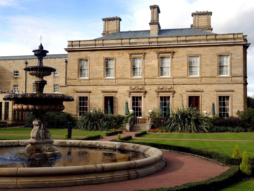 The exterior of Oulton Hall with a fountain in the courtyard