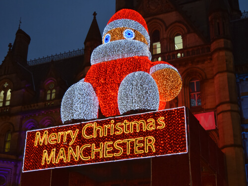 Close up of illuminated Santa on a building with Merry Christmas Manchester written beneath it