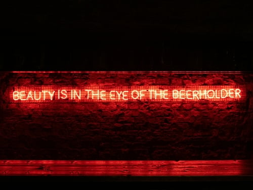 A neon sign that says Beauty is in the Eye of the Beerholder