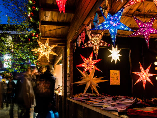 Paper Christmas star lights hanging from a Christmas market stall