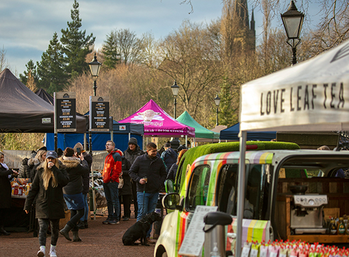 People are a busy open-air market with covered stalls