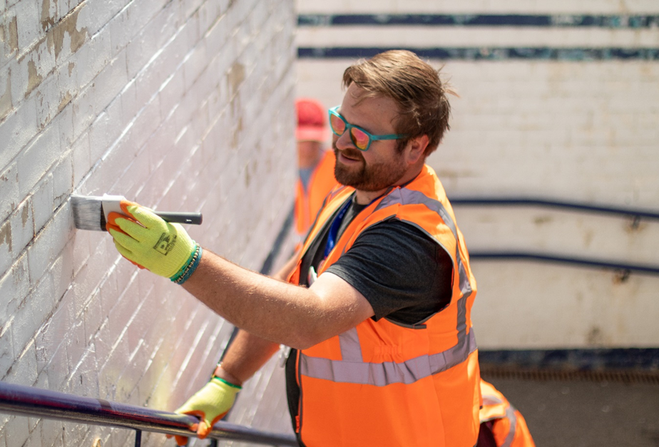 this-image-shows-a-volunteer-painting-the-underpass-at-starbeck-station