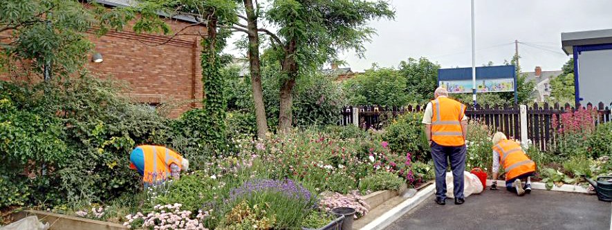 this-image-shows-volunteers-tending-to-flowebeds-at-one-of-northern-s-stations