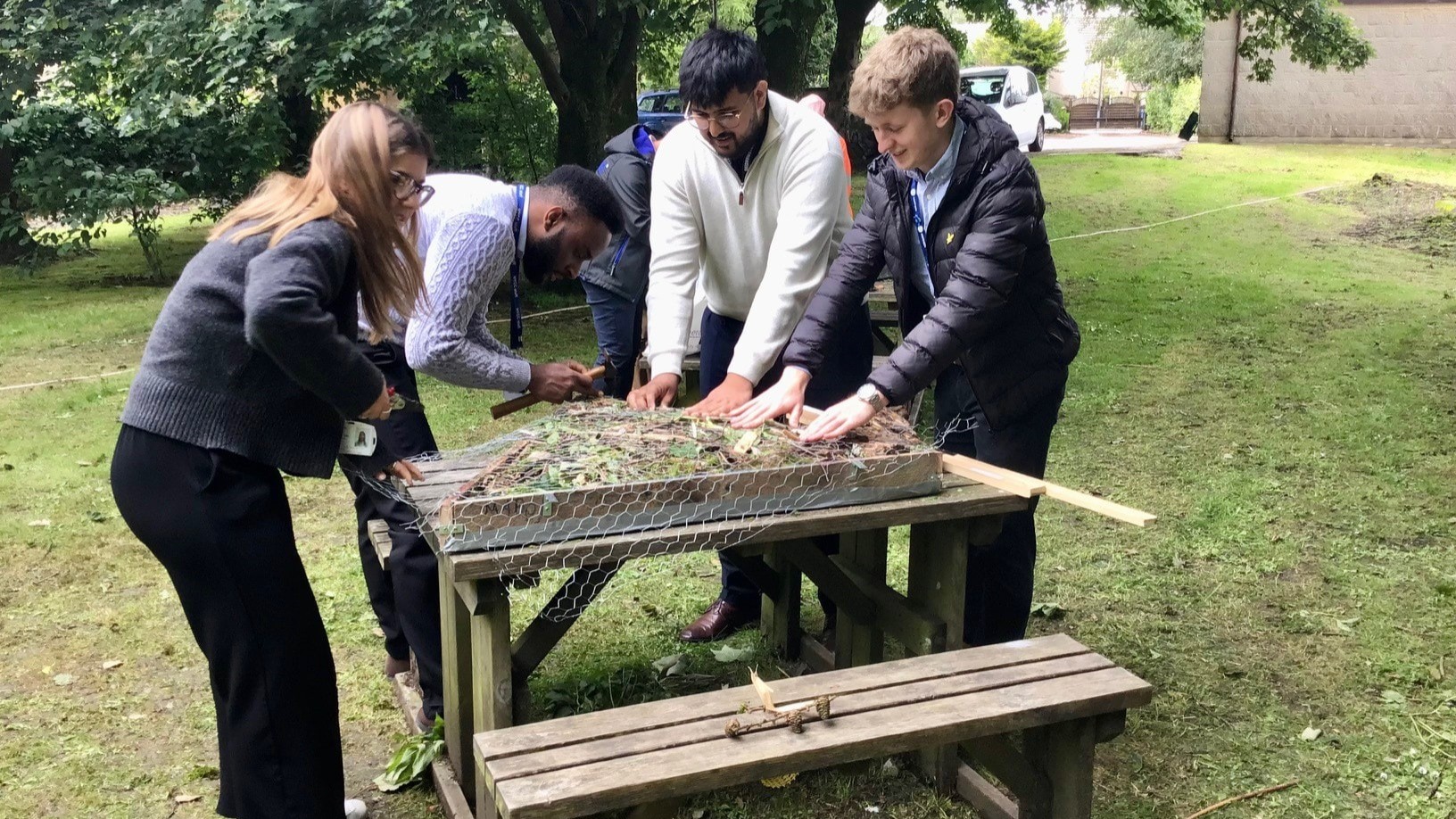 Image shows Northern employees creating bug hotel