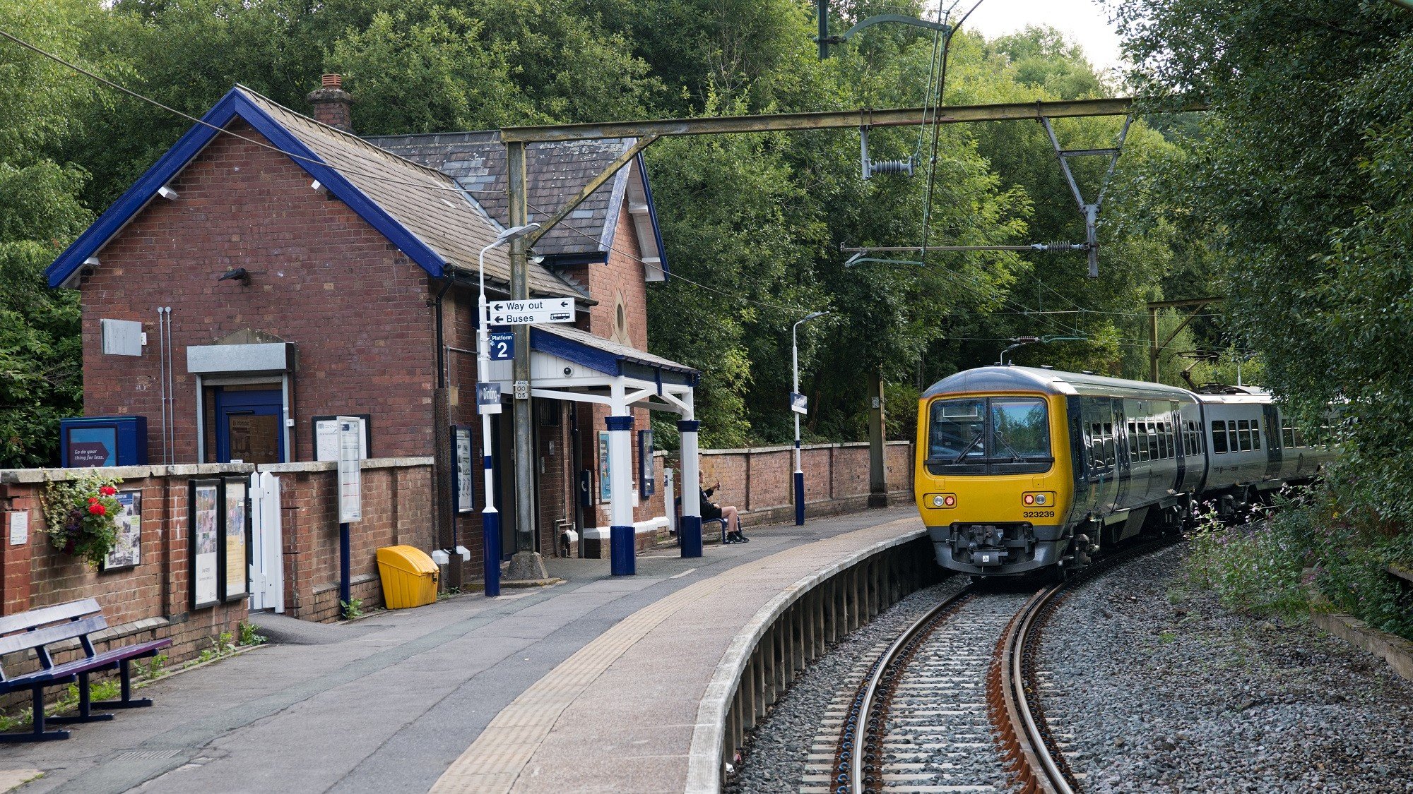 Image shows passenger sat at station as Northern train arrives