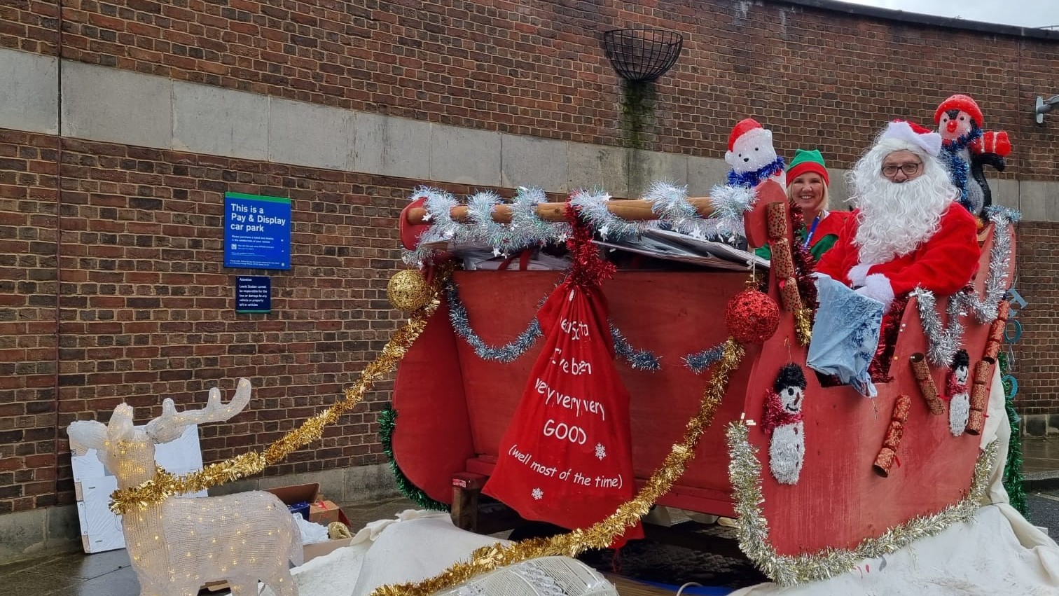 Santa and his elf in a sleigh made by Northern colleagues