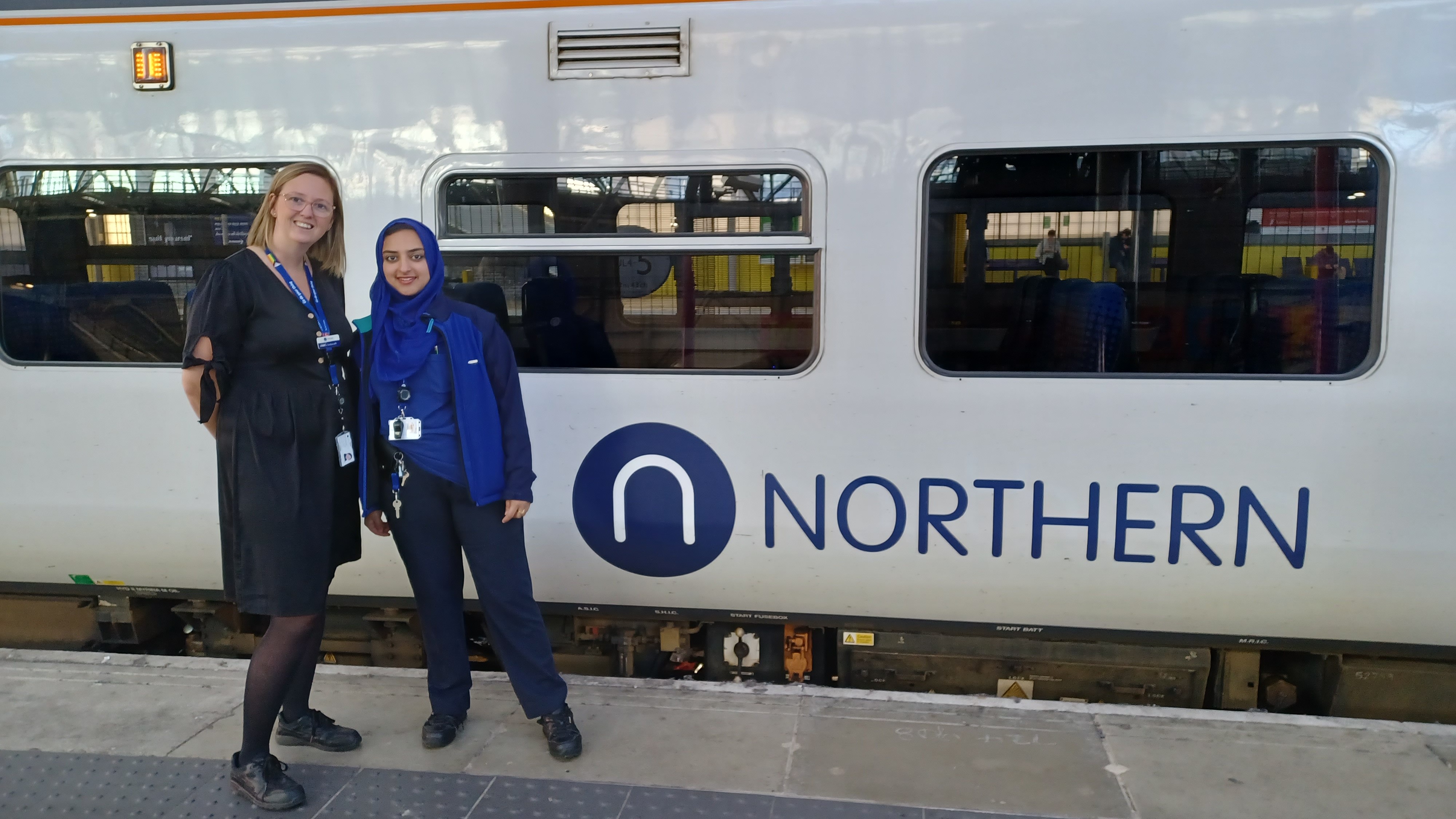 Zahida stands with her manager Kelly Dodsworth next to a Northern train